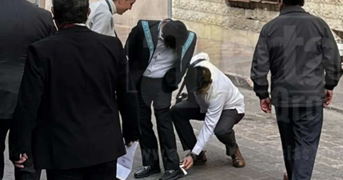Dos colaboradores le limpian los zapatos al presidente de la Corte, Hugo Aguilar, previó al 109 Aniversario de la Constitución de 1917