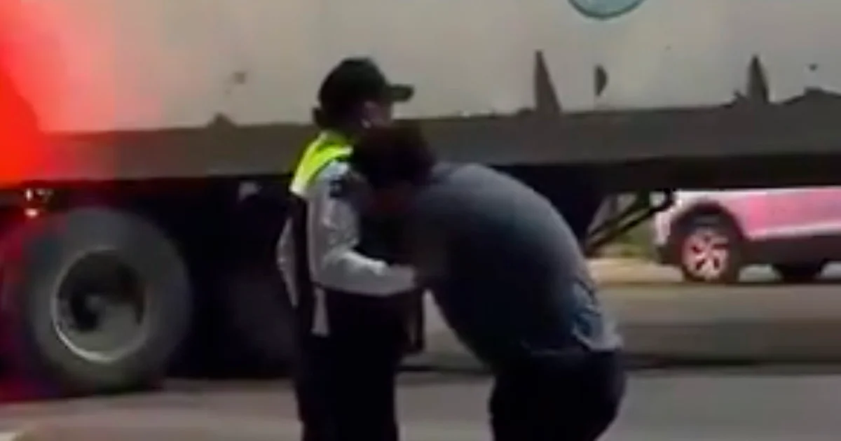 Un oficial consuela al sobreviviente de un fatal choque en moto en Cancún. El accidente ocurrió tras un retorno en 'U'